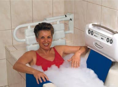 Lächelnde Frau mit Badewannenlift gefüllter Badewanne in der Schweiz